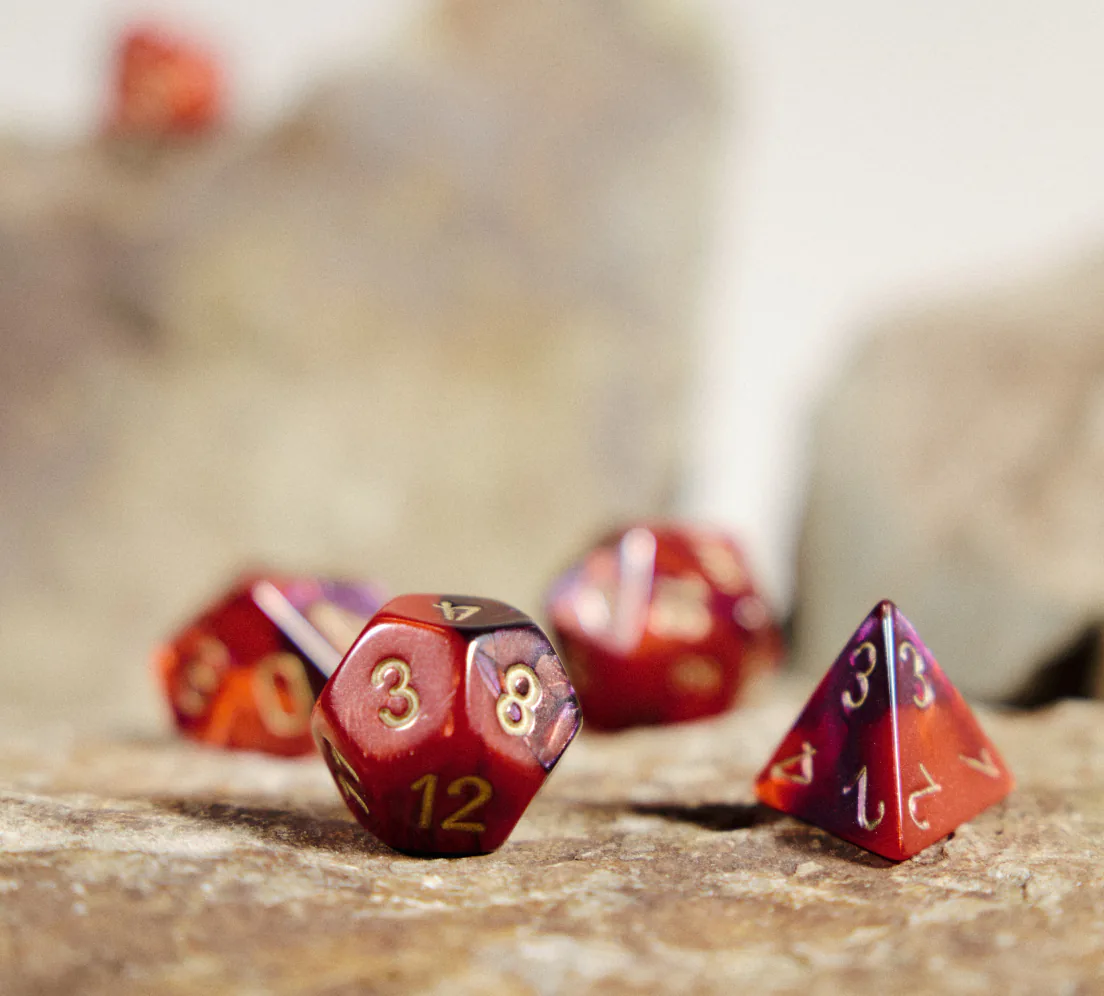 Dés de jeu de rôle rouges posés sur une pierre