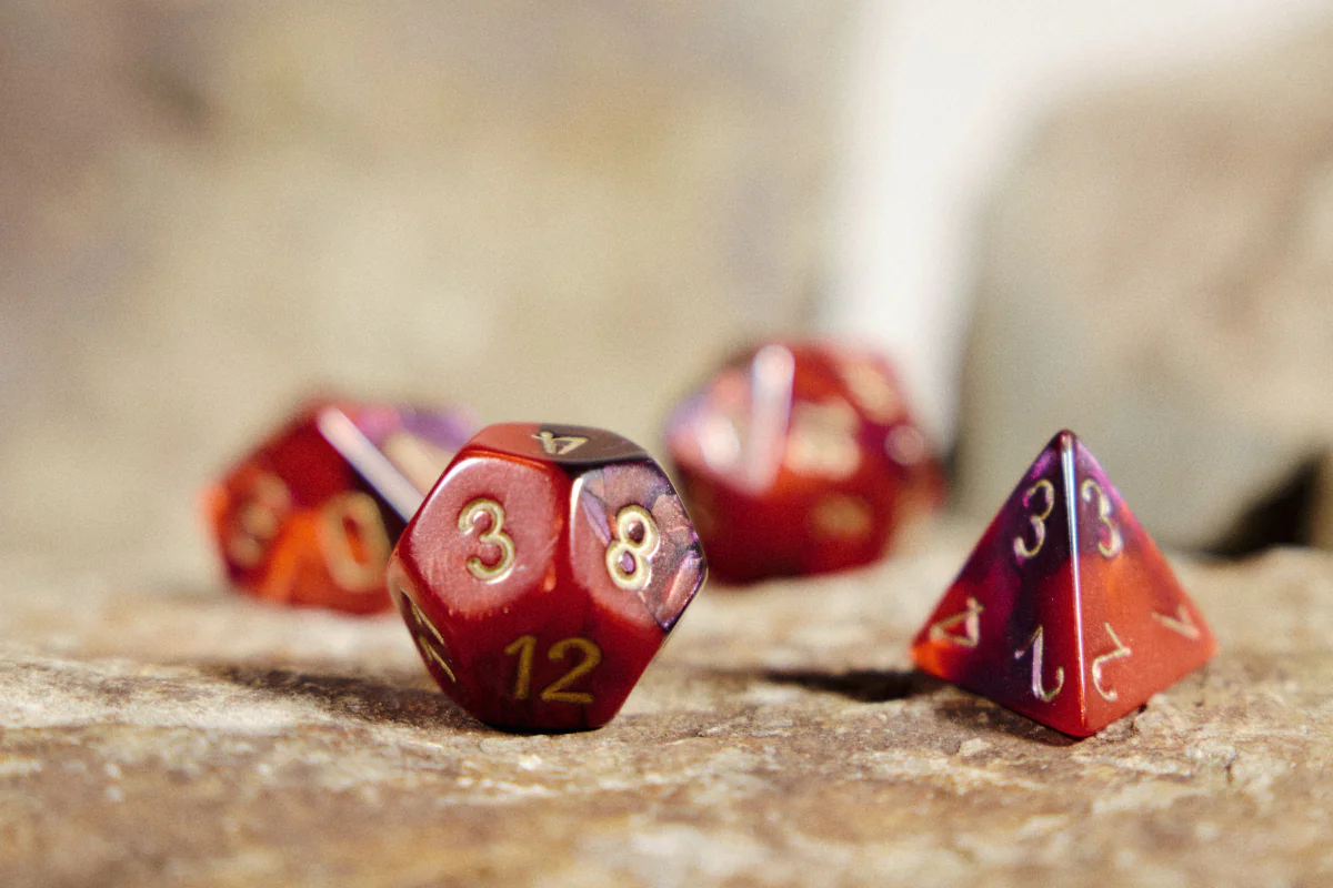 Dés de jeu de rôle rouges posés sur une pierre